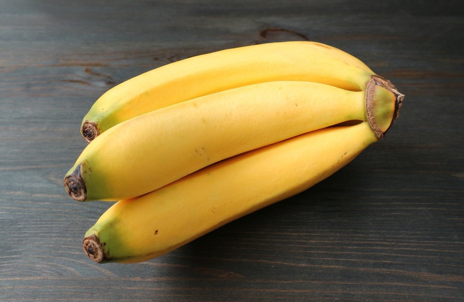 Half hand of fresh ripe banana isolated black wooden background Model Released Property Released xkwx banana cavendish banana dessert banana musa acuminata colla ripe fresh fruit yellow skin hand bunc ...