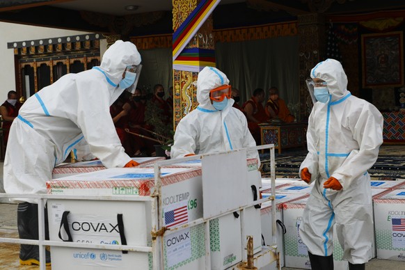 This photograph provided by UNICEF shows airport personnel in protective suit handle unloaded consignment as 500,000 doses of Moderna COVID-19 vaccine gifted from the United States arrived at Paro Int ...