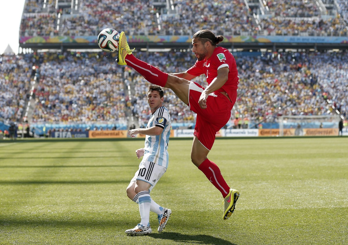 epa04293968 Lionel Messi (L) of Argentina in action against Ricardo Rodriguez (R) of Switzerland during the FIFA World Cup 2014 round of 16 match between Argentina and Switzerland at the Arena Corinth ...