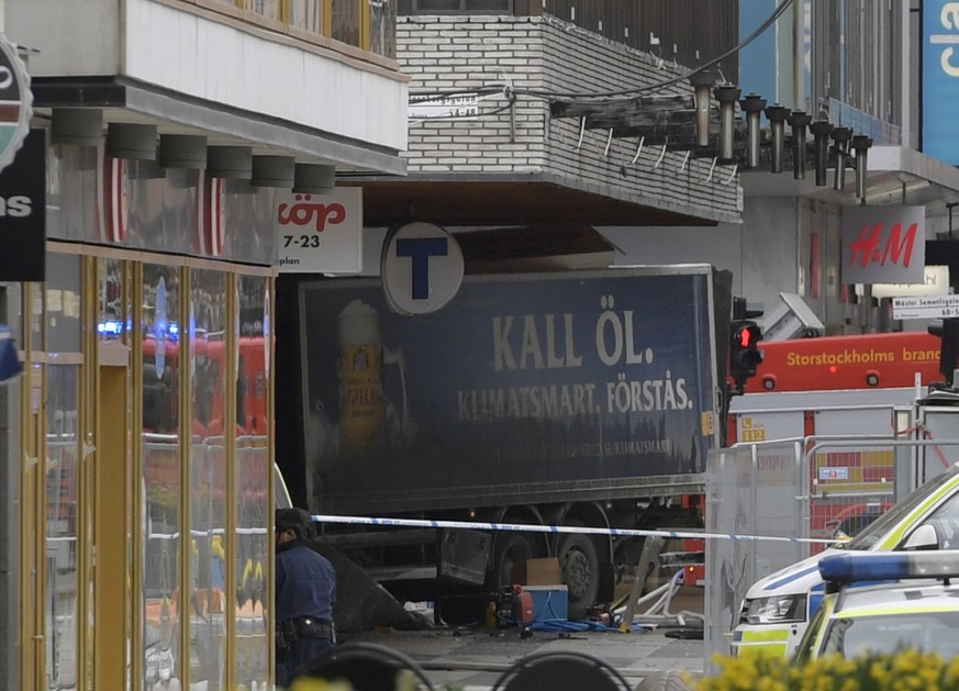 The rear of a truck, left, protrudes after it crashed into a department store injuring several people in central Stockholm, Sweden, Friday April 7, 2017. (Anders Wiklund , TT News Agency via AP)