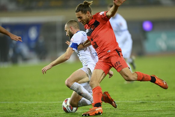 Le milieu lausannois Christian Schneuwly, gauche, lutte pour le ballon avec le defenseur luganais Numa Lavanchy, droite, lors de la rencontre a huis-clos de football de Super League entre le FC Lausan ...