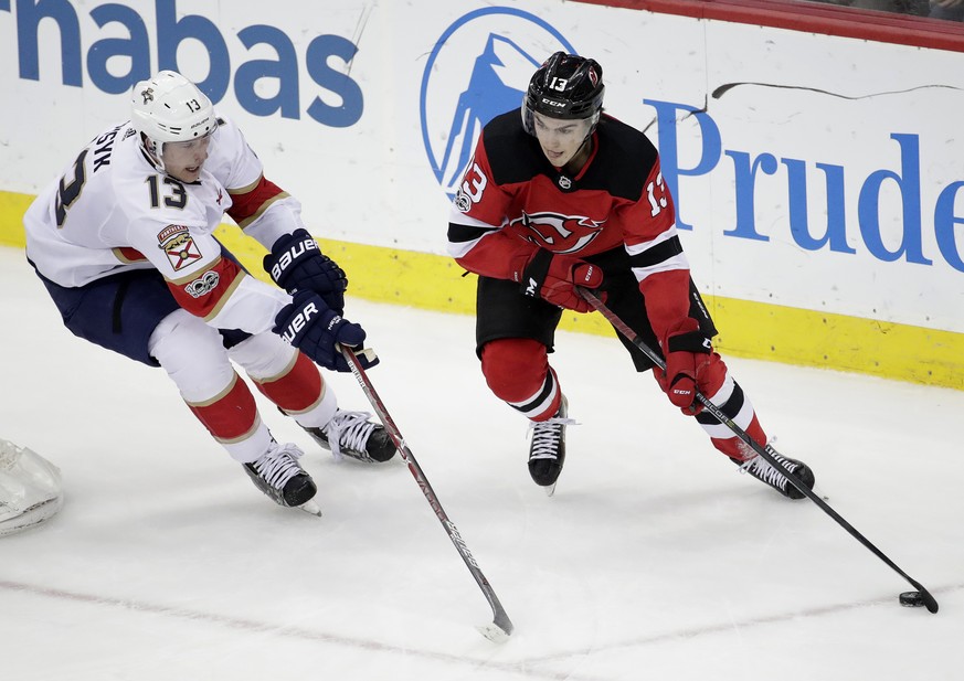 Florida Panthers defenseman Mark Pysyk, left, applies pressure to New Jersey Devils center Nico Hischier, of Switzerland, during the third period of an NHL hockey game, Saturday, Nov. 11, 2017, in New ...