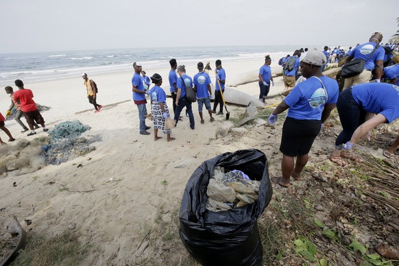 epa07447159 Participants pick up plastic waste during official clean up of plastic and other wastes at the Snow beach in Paynesville City, outside Monrovia, Liberia, 18 March 2019. According to a rele ...