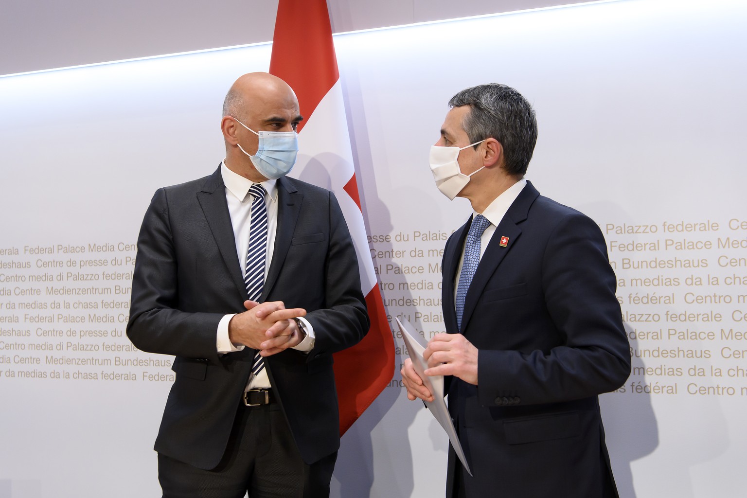 Bundespraesident Ignazio Cassis, rechts, und Bundesrat Alain Berset, links, sprechen nach einer Medienkonferenz ueber die neusten Entscheide des Bundesrates zur Coronavirus-Pandemie, am Mittwoch, 2. F ...