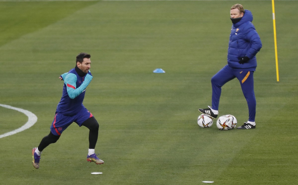 epa08942354 FC Barcelona's head coach Ronald Koeman (R) and striker Lionel Messi (L) during a training session of the team on the eve of their Spanish Supercup final match against Athletic Bilbao ...
