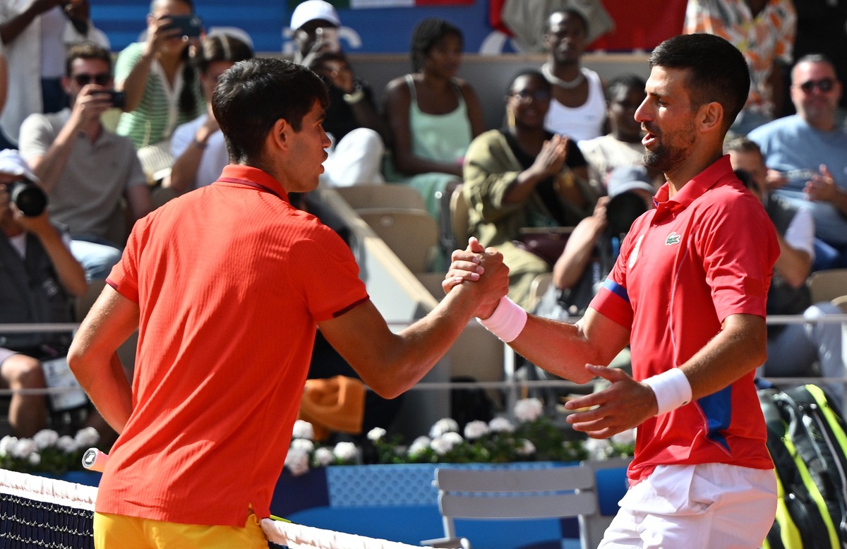 epa11525334 Novak Djokovic of Serbia (R) shakes hands with Carlos Alcaraz of Spain (L) after the Men Singles gold medal match of the Tennis competitions in the Paris 2024 Olympic Games, at the Roland  ...