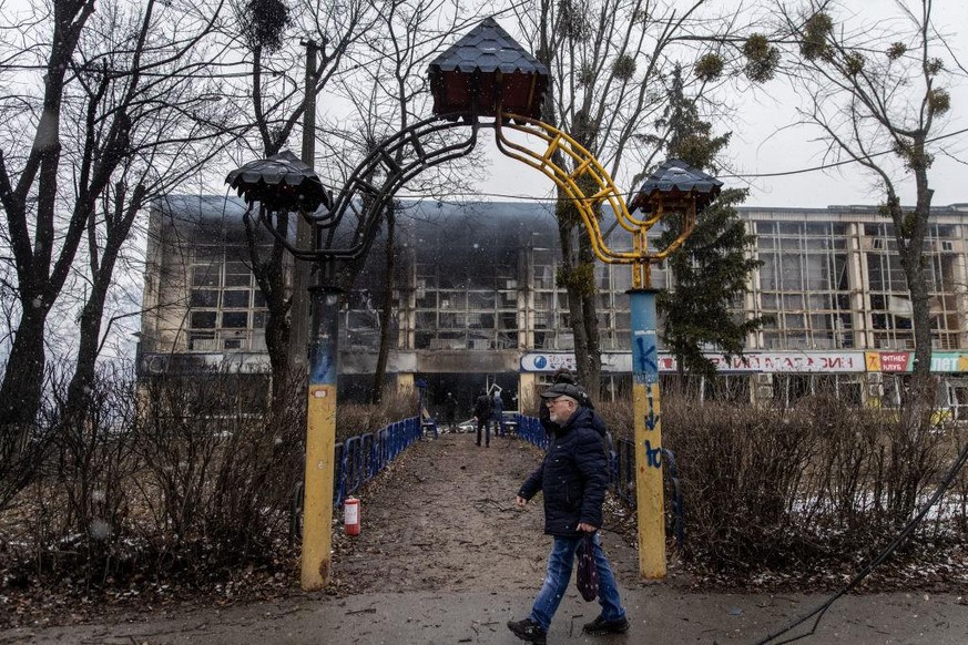 KYIV, UKRAINE - MARCH 02: A man walks past the entrance of a damaged sports complex building across the street from the Kyiv TV Tower on March 02, 2022 in Kyiv, Ukraine. The country&#039;s president,  ...