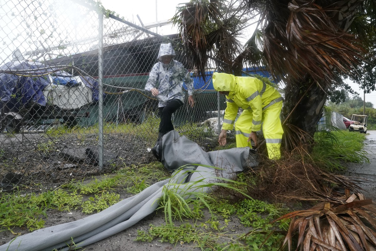 Robert and Donna Antognoni work to secure a tarp ahead of Hurricane Ian, Wednesday, Sept. 28, 2022, in Saint Petersburg, Fla. The U.S. National Hurricane Center says Ian's most damaging winds hav ...