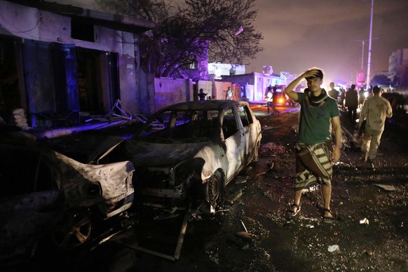 epa09555063 Yemenis inspect the scene of a car bomb attack outside Aden airport in the southern port city of Aden, Yemen, 30 October 2021. A car bomb exploded near the entrance to Aden airport in the  ...