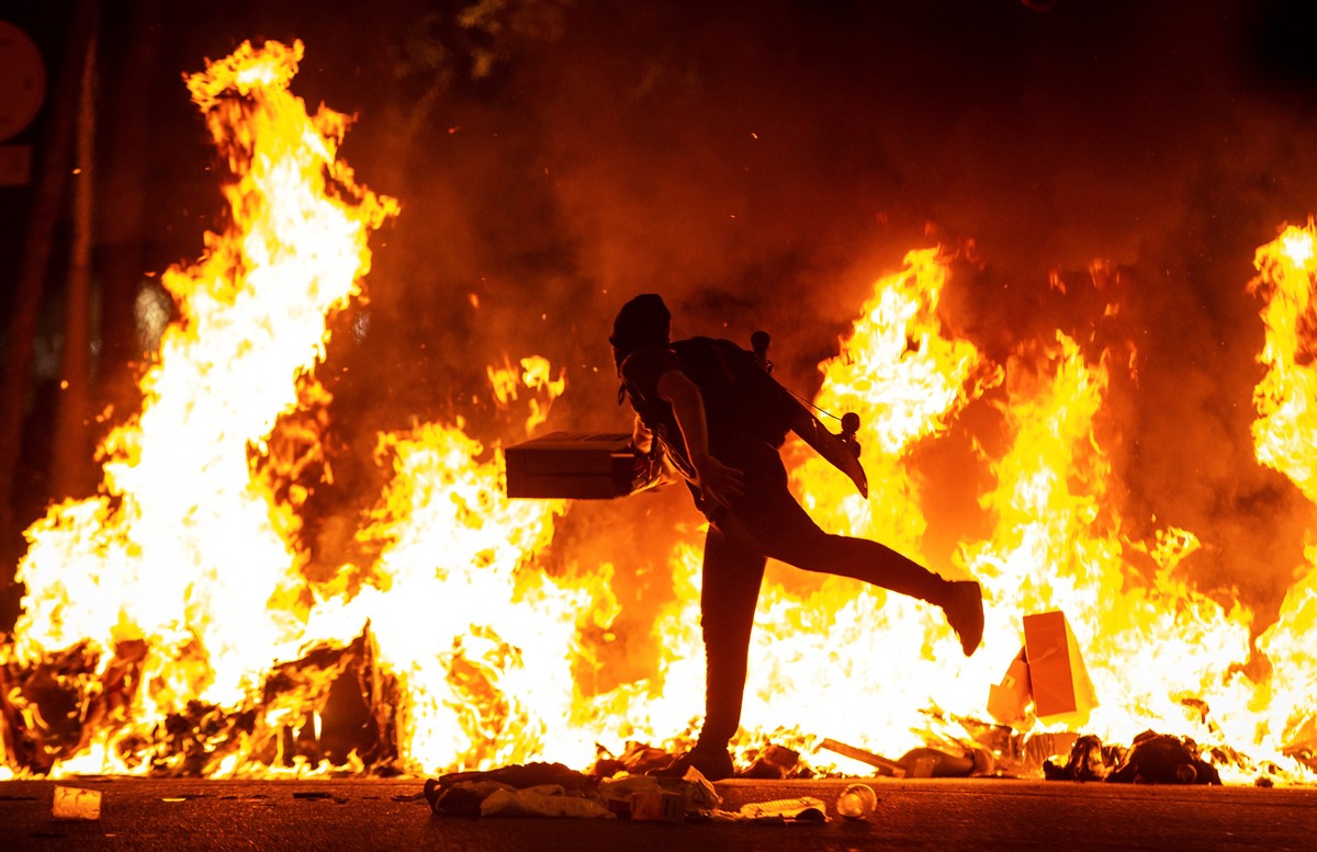 epaselect epa07923748 A protester runs accross the street in front of a burning barricade during a rally against the sentence ruled by Supreme Court on 'proces' trial' in downtown Barce ...