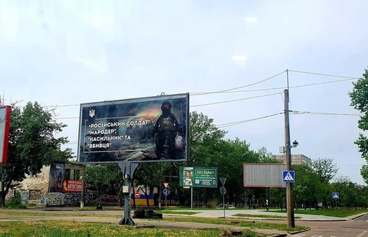 Ein Ork in Uniform. "Russischer Soldat: Rumtreiber, Vergewaltiger und Mörder" steht auf dem Plakat in Mykolajiw.