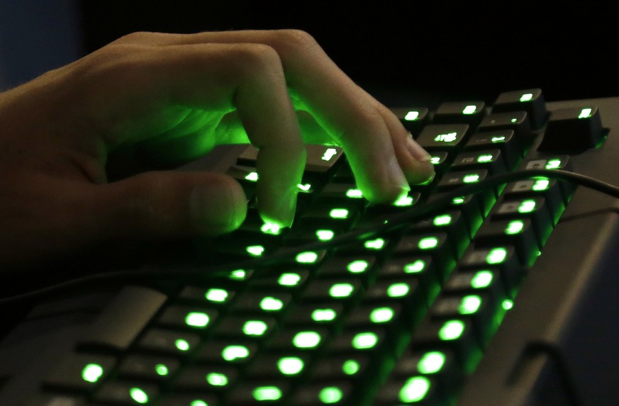 A gamer&#039;s hand rests on an illuminated keyboard Friday, Aug. 29, 2014, at the Penny Arcade Expo, a fan-centric celebration of gaming in Seattle. The event is expected to be attended by roughly 85 ...