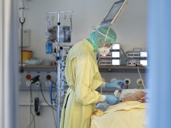 Aerzte und Pflegende kuemmern sich um Covid-Patienten auf der Covid-19-Intensivabteilung im Stadtspital Triemli am 10. Dezember 2020 in Zuerich. (KEYSTONE/Gaetan Bally)