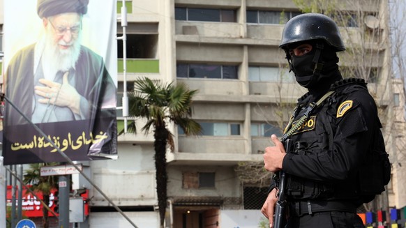 epa12861676 A member of the Iranian security forces stands guard next to a banner showing of late Iranian supreme leader Ayatollah Ali Khamenei, in Tehran, Iran, 31 March 2026. A joint US and Israeli  ...
