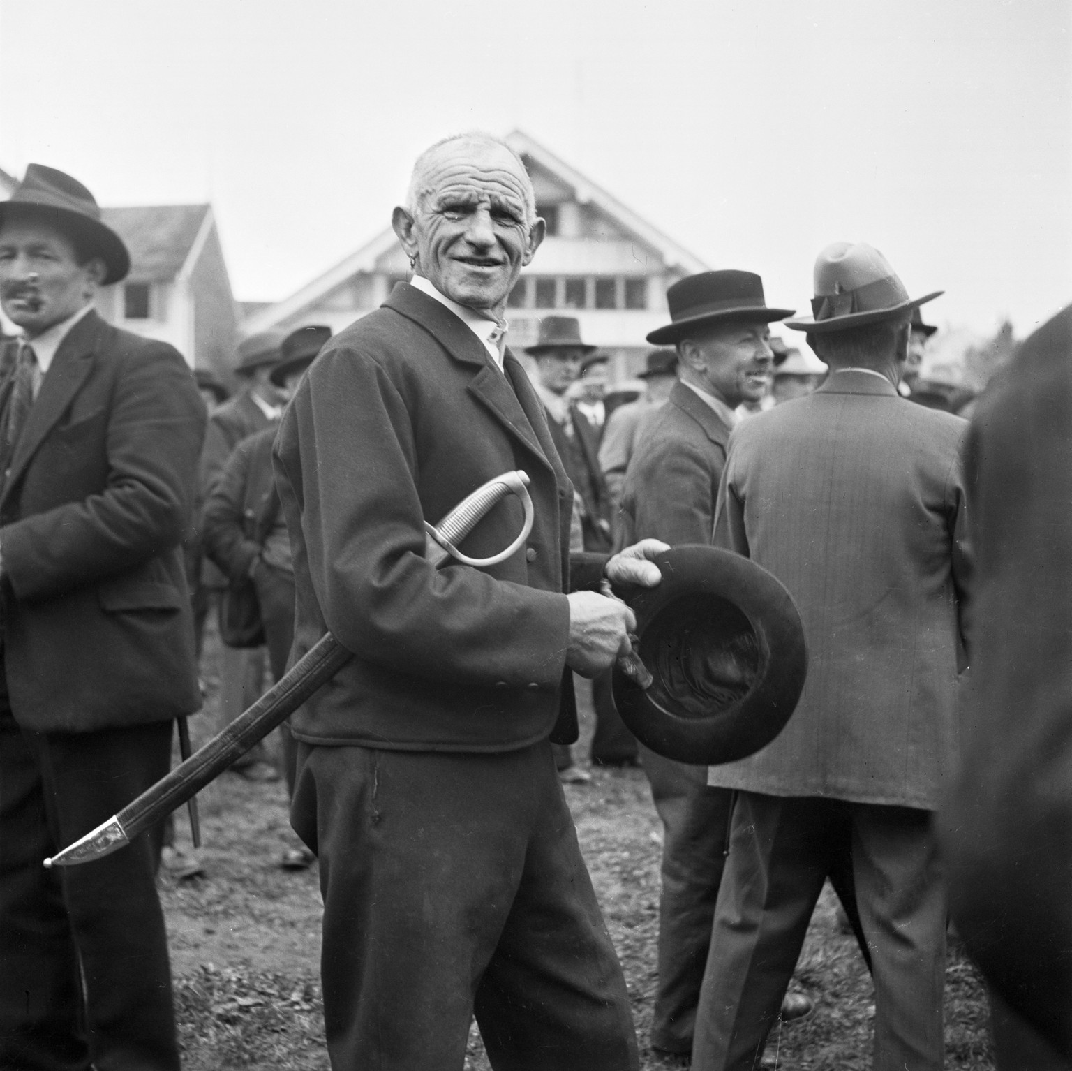 Ein stimmberechtigter Bürger steht mit seinem Degen unter dem Arm an der Landsgemeinde von Appenzell Ausserrhoden in Hundwil, Schweiz, aufgenommen im April 1937.