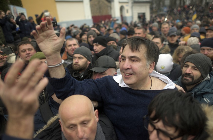 Former Georgian president Mikheil Saakashvili, center, greets protesters after he escaped with help from supporters and led them on a march toward parliament, where they planned to call for President  ...