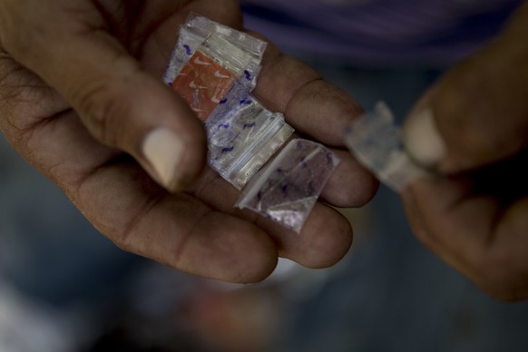 In this Dec. 14, 2018 photo, a heroin user gives empty heroin bags to a member of the &quot;Intercambios Puerto Rico&quot; needle exchange program to be tested for fentanyl, after injecting heroin int ...