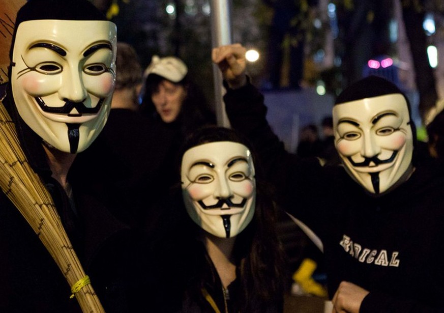 Occupy Wall Street protestors wearing Guy Fawkes masks commonly associated with the hacker group Anonymous wait for their turn to step off at the 39th annual Village Halloween Parade, Monday, Oct. 31s ...