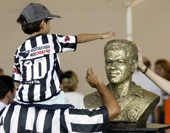 Ein Bub tätschelt die Garrincha-Statue im nicht minder legendären Maracana-Stadion in Rio de Janeiro.