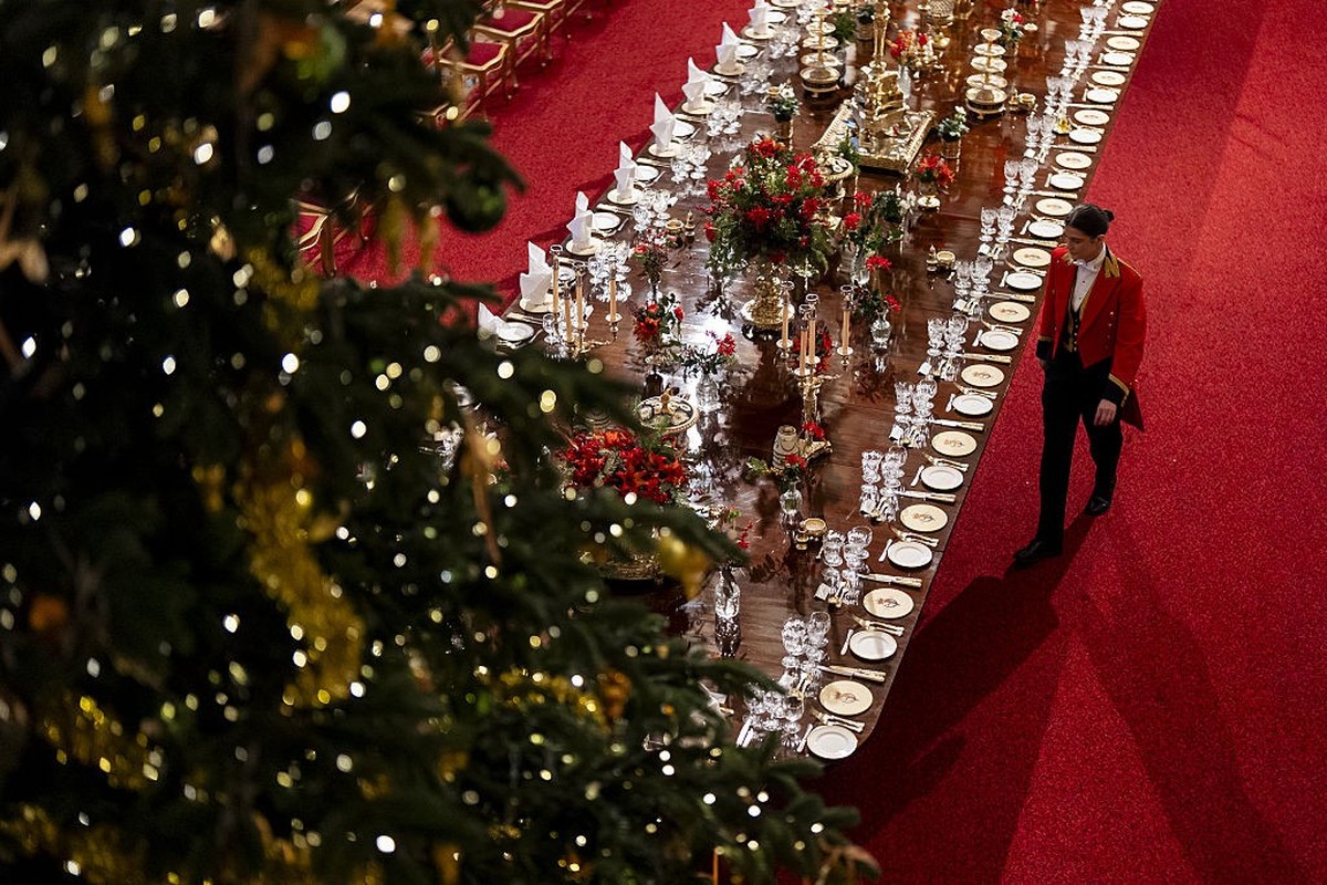 WINDSOR, ENGLAND - DECEMBER 03: A member of Royal Household staff arranges table placements ahead of the state banquet for the German President Frank-Walter Steinmeier and his wife Elke Budenbender, o ...