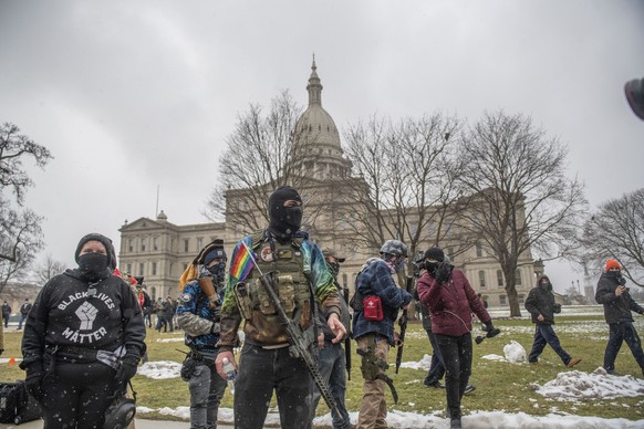 Members of the Boogaloo Bois leave the Capitol building Sunday, Jan. 17, 2021, in downtown Lansing, Mich. (Nicole Hester/Ann Arbor News via AP)