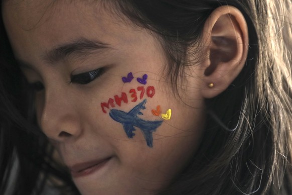 epa06576669 A girl with the letters &#039;MH370&#039; painted on her cheek looks on during a remembrance ceremony to mark the fourth anniversary of the Malaysian Airlines flight MH370 plane&#039;s dis ...