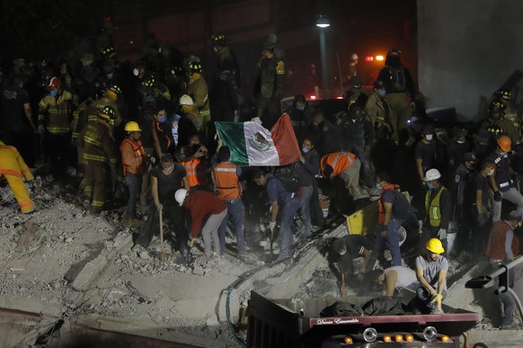 epa06214727 Rescue personell and civilians try to recover living people from collapsed buildings following a 7.1 magnitude earthquake, in Mexico City, Mexico, 19 September 2017. At least 139 people di ...