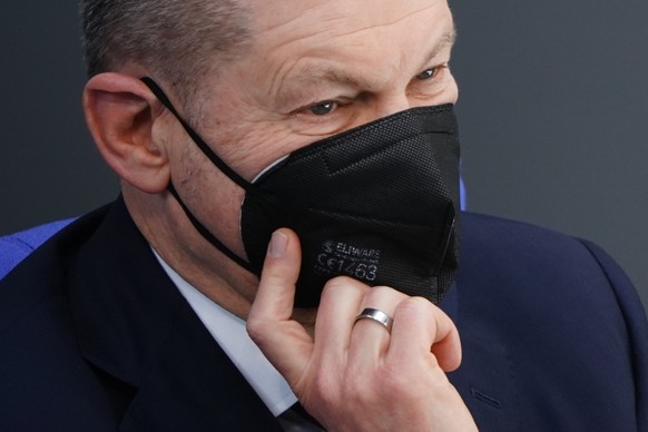 epa09788611 German Chancellor Olaf Scholz looks on wearing a face mask after delivering a government declaration at the German parliament &#039;Bundestag&#039; in Berlin, Germany, 27 February 2022. Th ...