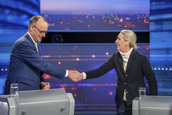 Friedrich Merz, left, of the German Christian Democratic Union and Alice Weidel, right, of the Alternative for Germany (AFD) party, shake hands as they take part in a tv discussion in Berlin, Germany, ...