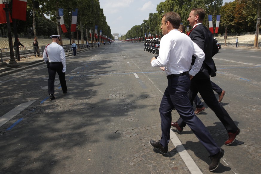 epa06888152 French President Emmanuel Macron runs to greet people after the traditional Bastille Day military parade on the Champs-Elysees avenue in Paris, France, 14 July 2018. EPA/PHILIPPE WOJAZER / ...