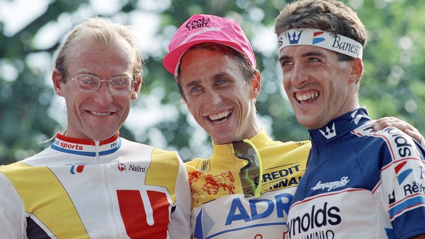 In this July 23, 1989 photo, French rider Laurent Fignon, left, American rider Greg LeMond, center, and Spanish rider Pedro Delgado pose on the podium following LeMond's victory in the 76th Tour de Fr ...