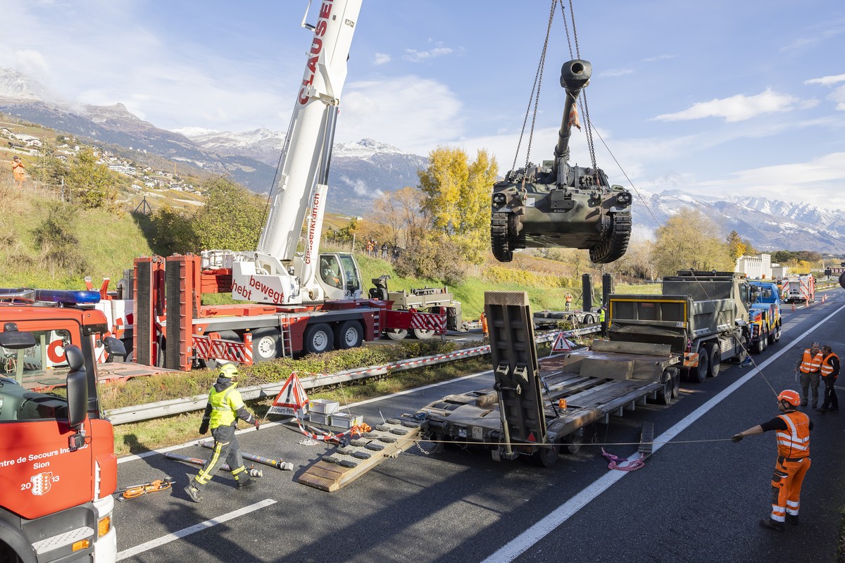 Une grue degage un camion de l?armee transportant un char blinde immobilises sur l?autoroute A9, entre Sion et Sierre suite a un accident entre deux camions de l'armee ce mardi 12 novembre 2024 a ...