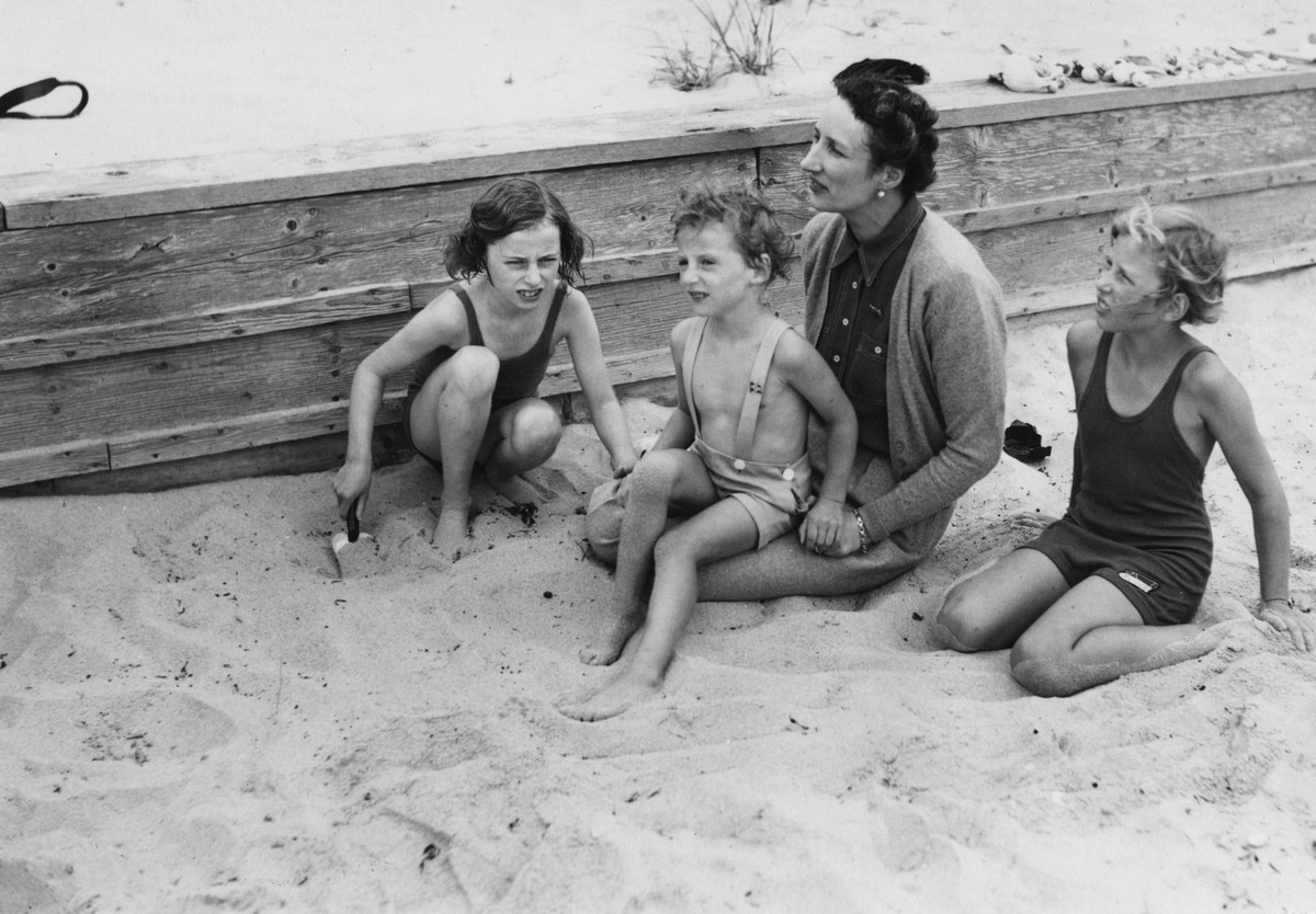 WIANNO, USA 1939. Kronprinsessan Märtha av Norge leker med barnen fr.v. Ragnhild, 9 ar, prins Harald, 3 ar, och prinsessan Astrid, 7 ar. Kungligheterna befinner sig i Cape Cod dit de tagit sin tillfly ...