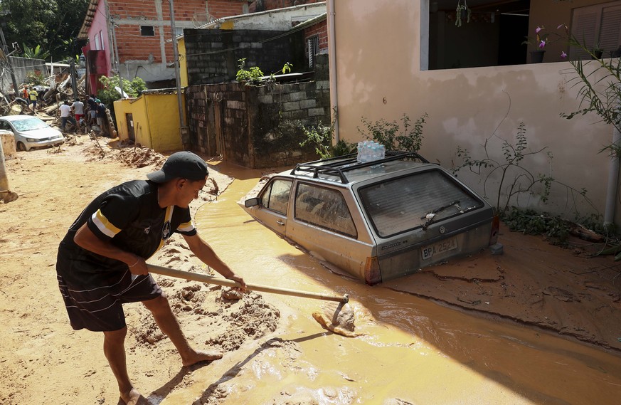 epa10482597 A man tries to rescue belongings after a landslide due to heavy rains in Sao Sebastiao, Sao Paulo state, Brazil, 21 February 2023. At least 44 people died due to heavy rains in Sao Paulo r ...