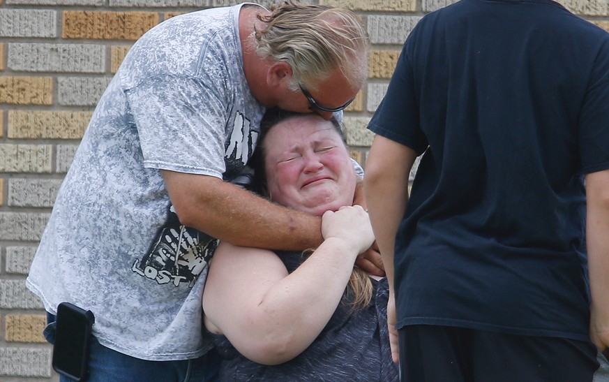 A man hugs a woman outside the Alamo Gym where parents wait to reunite with their children following a shooting at Santa Fe High School in Santa Fe, Texas, on Friday, May 18, 2018. (Michael Ciaglo/Hou ...