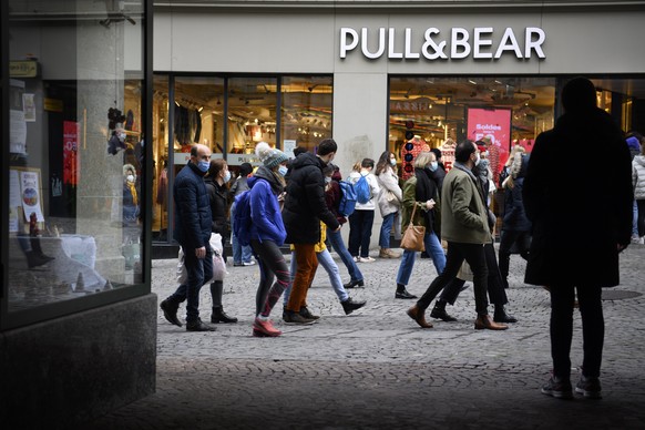 epa08941474 People wearing protective face masks line up in a queue outside the Pull &amp; Bear clothes shop during the last day of the opening of non-essential shops during the coronavirus disease (C ...