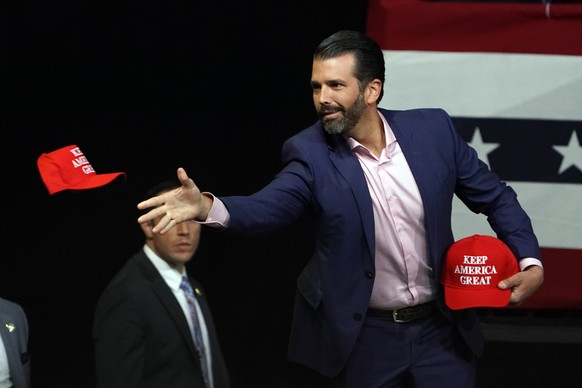 Donald Trump Jr. throws hat out to the crowd at a campaign rally for President Donald Trump Wednesday, Feb. 19, 2020, in Phoenix. (AP Photo/Rick Scuteri)