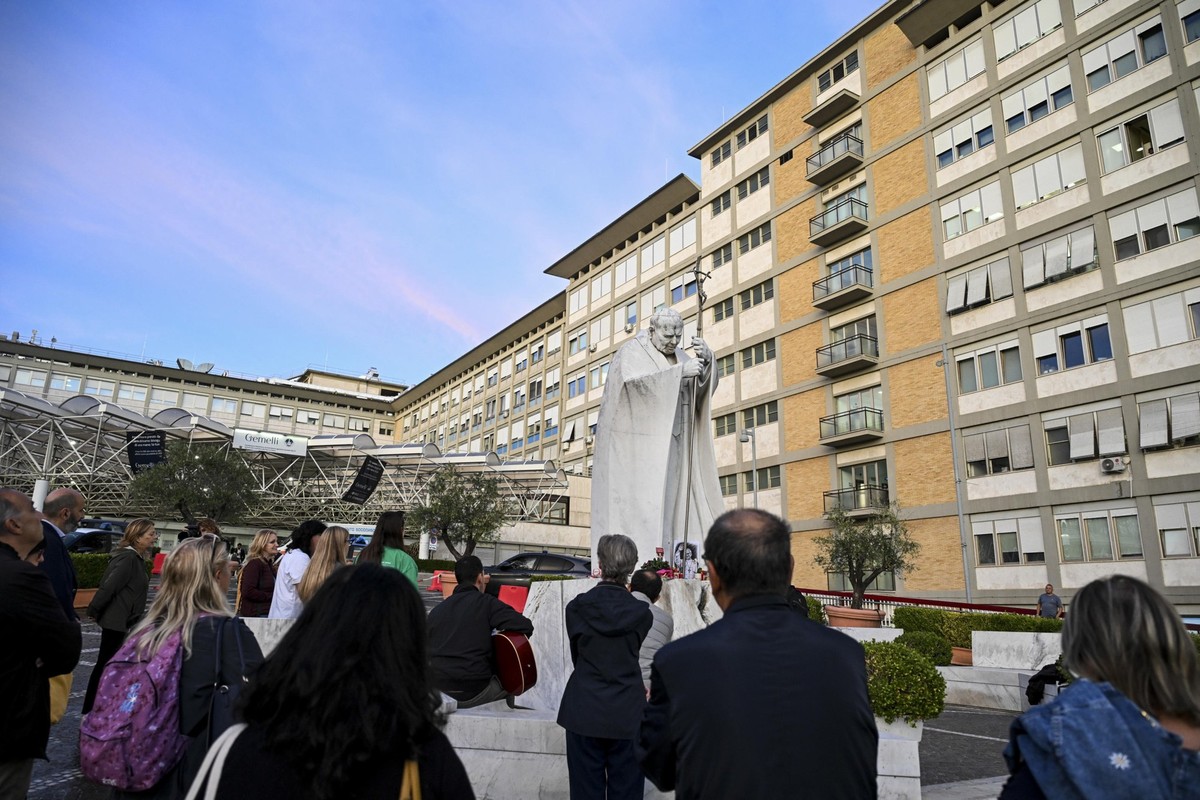 epa13307116 Faithful pray during the rosary at the statue of John Paul II outside Agostino Gemelli University Hospital, where Pope Leo XIV is hospitalized in Rome, Italy, 15 October 2026. According to ...