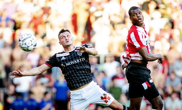 epa07735942 SV Eindhoven player Denzel Dumfries in action against FC Basel player Taulant Xhaka (L) during the second qualifying round for the Champions League match in Eindhoven, the Netherlands, 23  ...