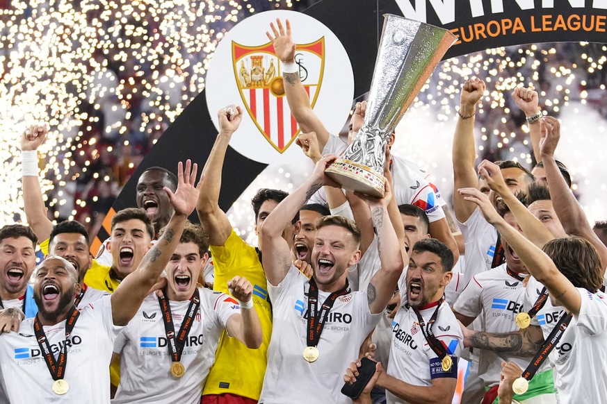 Sevilla&#039;s team captains Ivan Rakitic, center, and Jesus Navas, center right, lift the trophy after winning the Europa League final soccer match between Sevilla and Roma, at the Puskas Arena in Bu ...