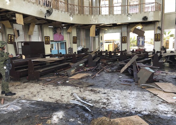 In this photo provided by WESMINCOM Armed Forces of the Philippines, a soldier views the site inside a Roman Catholic cathedral in Jolo, the capital of Sulu province in the southern Philippines after  ...