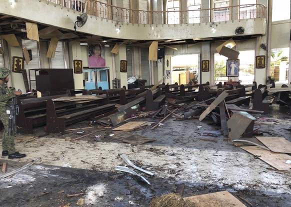 In this photo provided by WESMINCOM Armed Forces of the Philippines, a soldier views the site inside a Roman Catholic cathedral in Jolo, the capital of Sulu province in the southern Philippines after  ...