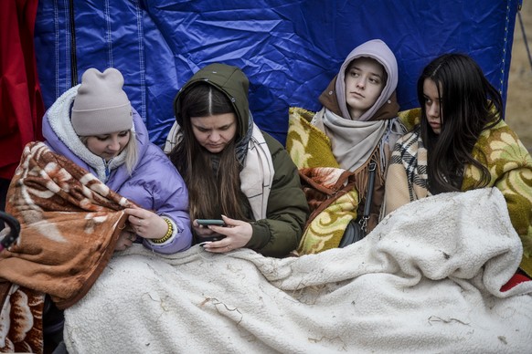 Refugees that fled the conflict from neighbouring Ukraine, await for transportation at the Romanian-Ukrainian border, in Siret, Romania, Sunday, Feb. 27, 2022. Since Russia launched its offensive on U ...