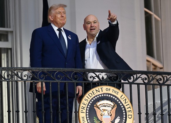 epa13037863 US President Donald Trump (C) and UFC CEO Dana White (R) talk on the Blue Room balcony during the playing of the national anthem before the 'UFC Freedom 250' event on the South L ...