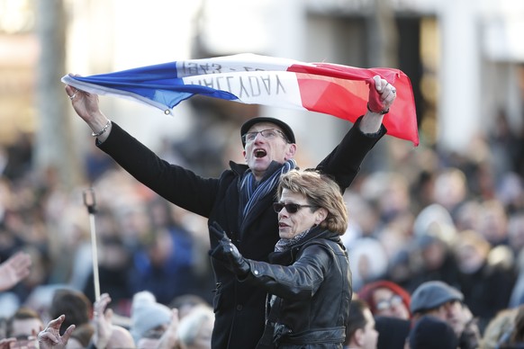 epa06378180 A fan holds a French flag as people gather ahead of the tribute ceremony to the late French rock legend Johnny Hallyday at the Madeleine Square in Paris, France, 09 December 2017. Johnny H ...
