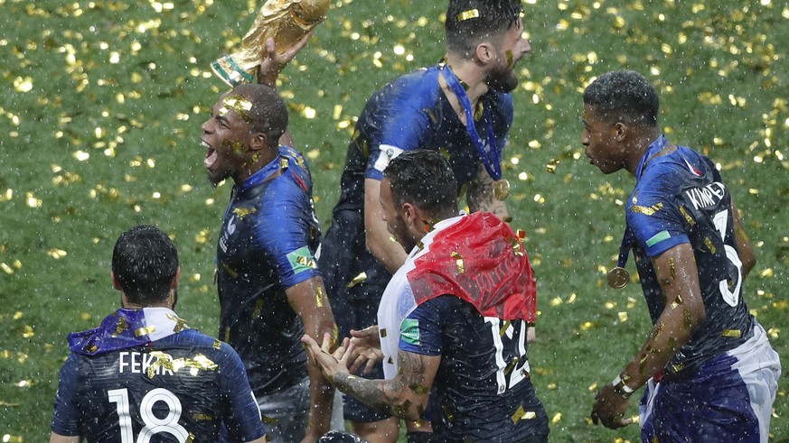 Paul Pogba jubelt mit seinen Teamkollegen und dem WM-Pokal.