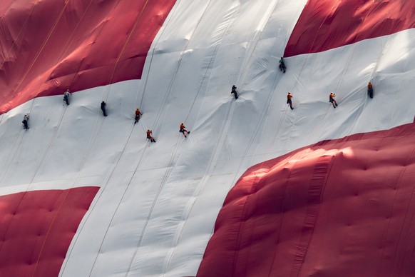 Hoehenarbeiter haengen eine 80x80 Meter grosse Schweizerfahne an einer Felswand unterhalb des Saentis auf, anlaesslich des Nationalfeiertags, am Dienstag, 31. Juli 2018, auf der Schwaegalp. (KEYSTONE/ ...