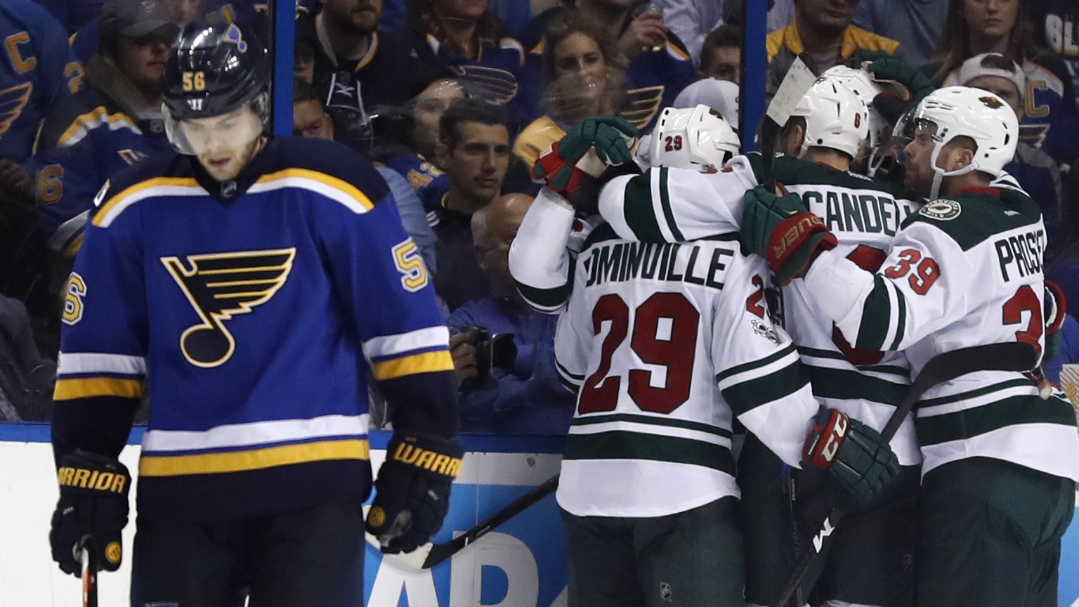 Members of the Minnesota Wild congratulate teammate Martin Hanzal, of the Czech Republic, on his goal as St. Louis Blues&#039; Magnus Paajarvi, left, of Sweden, skates past during the second period in ...