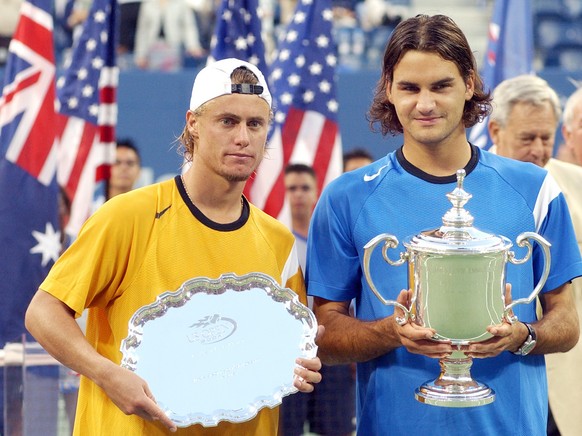Roger Federer, of Switzerland, right, poses with the championship trophy after defeating Lleyton Hewitt, of Australia, left, in the men's singles final at the U.S. Open tennis tournament in New York, Sunday, Sept. 12, 2004. (AP Photo/Richard Drew)