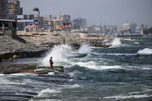 epaselect epa12268439 Fishermen sit by breakwaters in Alexandria, Egypt, 27 July 2025 (issued 28 July 2025). The Egyptian prime minister announced new coastal protection projects in Alexandria, aimed  ...
